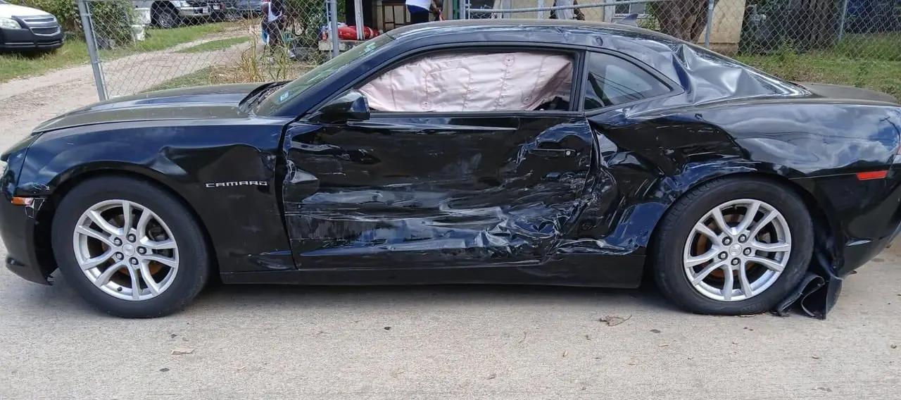 Black Chevrolet Camaro with side impact damage, damaged car buying
