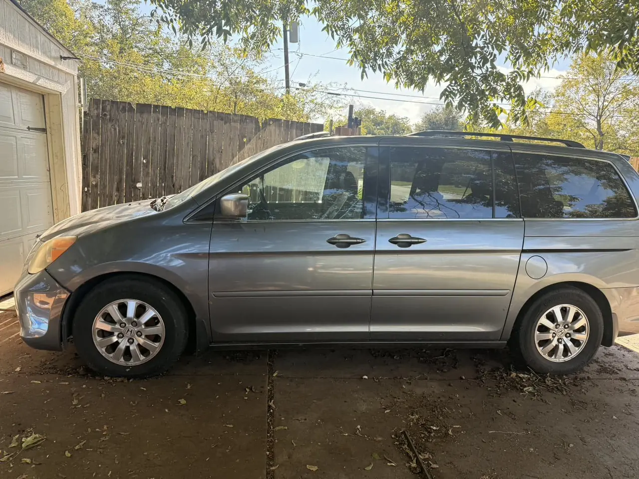 Gray Honda Odyssey minivan parked in a driveway before junk car pickup