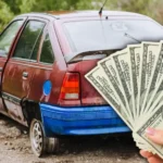 Rusty red hatchback with a fan of cash, cash for junk cars