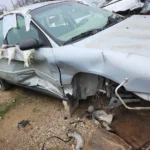 Silver sedan with severe side and front damage, cash for junk cars