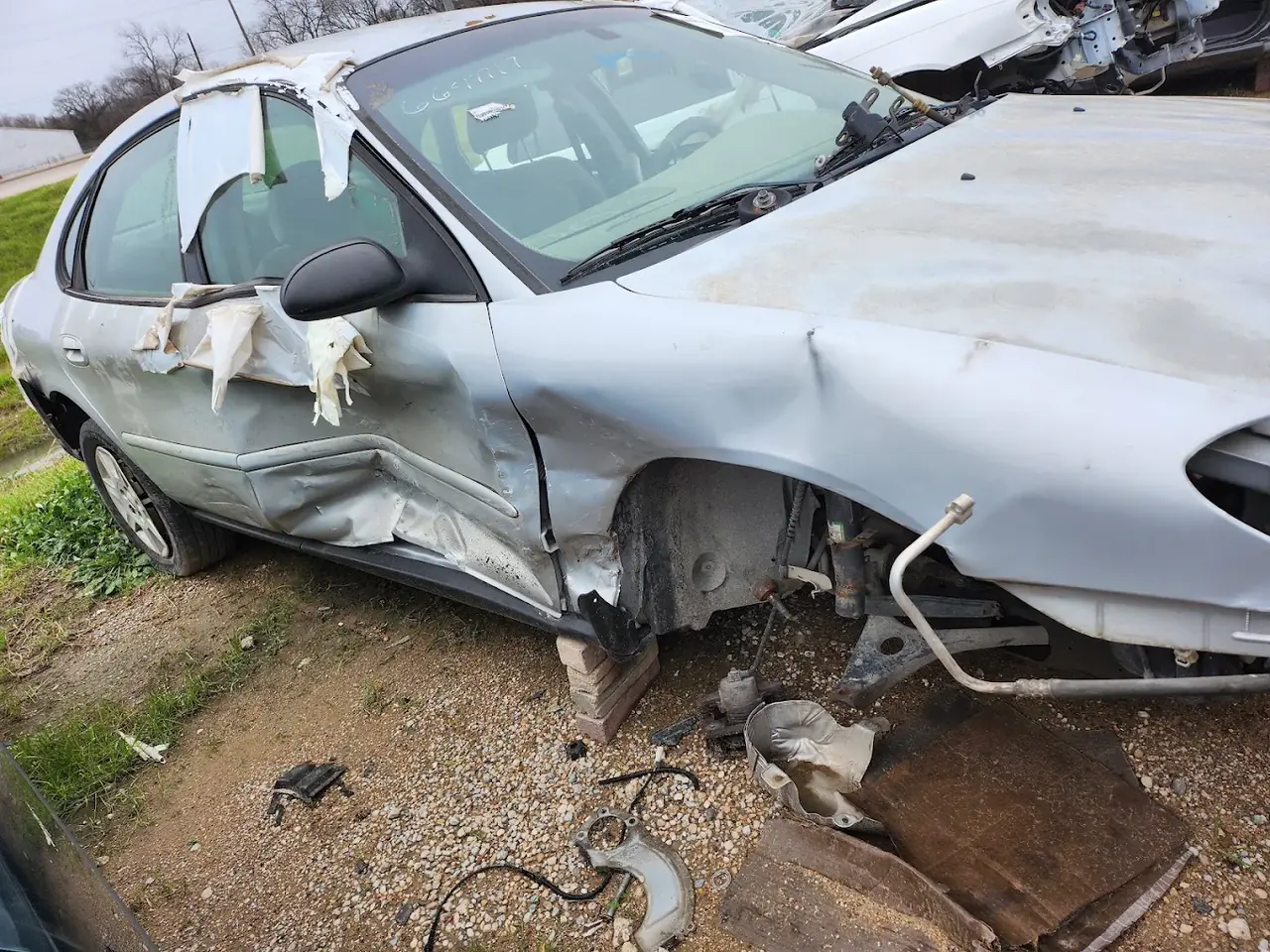 Silver sedan with severe side and front damage, cash for junk cars