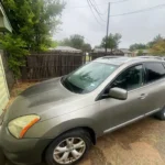 Gray Nissan Rogue SUV parked in a backyard, sell your used car