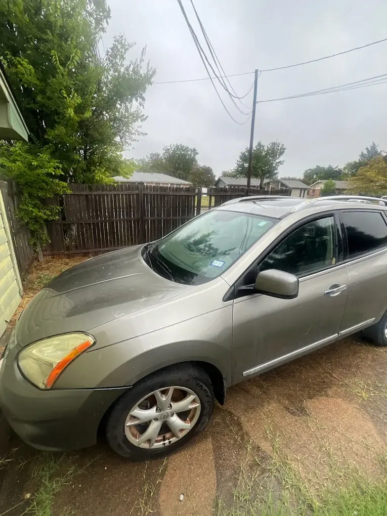Gray Nissan Rogue SUV parked in a backyard, sell your used car